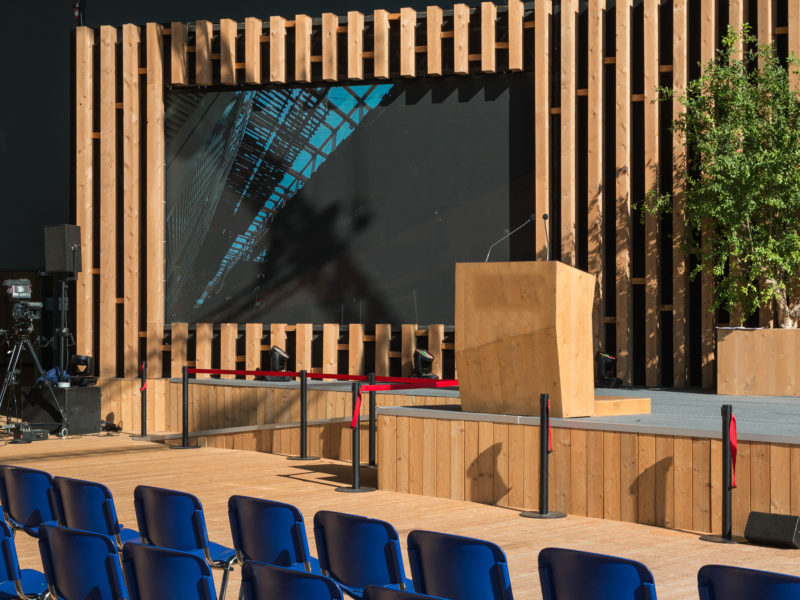 outdoor seating area with tv and podium on stage